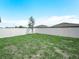 Large, fenced backyard with lush green grass and a sapling tree, perfect for outdoor activities at 440 Patricia Alford Dr, Haines City, FL 33844