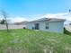 Spacious backyard with healthy green grass, a white fence, and solar panels on the roof at 440 Patricia Alford Dr, Haines City, FL 33844