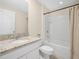 Well-lit bathroom featuring granite countertops, white cabinets, and a shower-tub combo with neutral shower curtain at 440 Patricia Alford Dr, Haines City, FL 33844