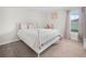 Bright bedroom featuring a metal bed frame, soft carpet, and a sunlit window with sheer curtains at 440 Patricia Alford Dr, Haines City, FL 33844