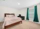 Serene bedroom with a full bed, work desk, and a window draped with elegant green curtains at 440 Patricia Alford Dr, Haines City, FL 33844