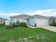 Charming, single-story home boasts a neatly landscaped yard, attached garage, and appealing curb appeal under a bright sky at 440 Patricia Alford Dr, Haines City, FL 33844