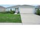 Single-story home has attached garage, appealing curb appeal, a landscaped yard and concrete driveway at 440 Patricia Alford Dr, Haines City, FL 33844