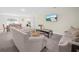 Bright living room features neutral walls, plush carpeting, comfortable sofas, and natural light from the dining area at 440 Patricia Alford Dr, Haines City, FL 33844