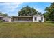 A long grassy backyard has a lanai with a view of the trees in this exterior image at 4901 Lindsay Ct, Orlando, FL 32821