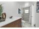 Well-lit bathroom features a vanity with white countertop, a toilet and a walk-in shower with marble tiling at 4901 Lindsay Ct, Orlando, FL 32821