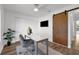 Home office in the bedroom featuring a sliding barn door, large desk, and double-door closet at 4901 Lindsay Ct, Orlando, FL 32821