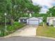 Well-maintained home featuring an attached two-car garage, lush lawn, and mature trees in a desirable neighborhood at 4901 Lindsay Ct, Orlando, FL 32821