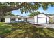 Charming single-Gathering home with an attached two-car garage and manicured lawn, shaded by a mature tree at 4901 Lindsay Ct, Orlando, FL 32821