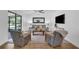 Bright living room featuring two comfy chairs, a cozy couch, and a sliding door to the outside patio at 4901 Lindsay Ct, Orlando, FL 32821