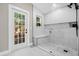 Luxurious bathroom with a glass enclosed walk-in shower, white tile, a window, and a bench at 5 W Village Dr, Oviedo, FL 32765