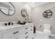 Elegant bathroom featuring a marble countertop vanity, modern fixtures, a toilet and a mirror at 5 W Village Dr, Oviedo, FL 32765