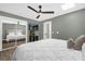 Relaxing bedroom featuring a mirrored closet door, wall-mounted TV, and fresh white bedding at 5 W Village Dr, Oviedo, FL 32765