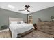 Comfortable bedroom with a light-colored queen bed, modern ceiling fan and a bright skylight at 5 W Village Dr, Oviedo, FL 32765