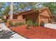Landscaped detail of side yard with red mulch and mature plantings at 5 W Village Dr, Oviedo, FL 32765