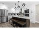 Modern kitchen with center island seating, stainless appliances, and decorative backsplash at 5 W Village Dr, Oviedo, FL 32765