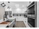 Modern kitchen featuring stainless steel appliances, white cabinetry, and a unique patterned backsplash at 5 W Village Dr, Oviedo, FL 32765