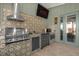 Inviting outdoor kitchen featuring stainless steel appliances, patterned tile backsplash, and access to the outdoors at 5 W Village Dr, Oviedo, FL 32765