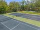 Dual tennis courts with basketball hoop next to a backyard pool and gazebo in a landscaped outdoor setting at 5 W Village Dr, Oviedo, FL 32765