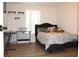 Bedroom with laminate wood floors, a bed with gray comforter, and window with bright natural light at 5054 Mcdonald Rd, Zellwood, FL 32798
