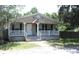 Single story home featuring a covered front porch, a welcoming entrance and nice landscaping at 5054 Mcdonald Rd, Zellwood, FL 32798