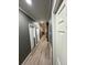 Long hallway featuring wood floors, neutral walls, and doorways leading to various rooms in the home at 5054 Mcdonald Rd, Zellwood, FL 32798