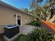 View of the backyard with a small brick patio, AC unit and landscaping at 563 Pleasant Grove Dr, Winter Springs, FL 32708