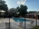 Community pool with lounge chairs surrounded by lush greenery and secure fencing at 563 Pleasant Grove Dr, Winter Springs, FL 32708