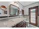 Elegant bathroom boasts double sinks, classic fixtures, wood door, and black/white accents at 6327 Ridgeberry Dr, Orlando, FL 32819
