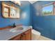 Blue bathroom showcasing ornate mirror, patterned sink, and tile flooring at 6327 Ridgeberry Dr, Orlando, FL 32819