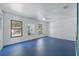 Spacious bedroom with a ceiling fan, three windows, and a bright blue floor at 6327 Ridgeberry Dr, Orlando, FL 32819
