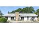 Home exterior features stone chimney, symmetrical design, and covered patio area at 6327 Ridgeberry Dr, Orlando, FL 32819