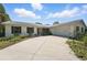 Low-angle view of a charming one-story home with a wide driveway and manicured landscaping at 6327 Ridgeberry Dr, Orlando, FL 32819