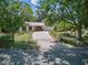 Charming front exterior of home with a large driveway and mature trees at 6327 Ridgeberry Dr, Orlando, FL 32819