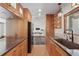 Well-lit kitchen featuring warm wood cabinetry, stainless steel appliances, and a modern sink at 6327 Ridgeberry Dr, Orlando, FL 32819