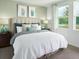 Serene bedroom with soft lighting, neutral paint, decorative pillows, large windows and bedside tables at 658 Pennywort St, Lake Alfred, FL 33850