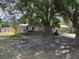 Exterior view of home with screened porch, mature trees, and overgrown yard at 749 Saddlewood Blvd, Lakeland, FL 33809