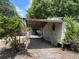 Side view of home with covered carport and some mature trees at 749 Saddlewood Blvd, Lakeland, FL 33809