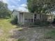 Exterior side view of home with screened porch and overgrown yard at 749 Saddlewood Blvd, Lakeland, FL 33809