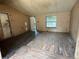 Bare living room featuring a window, damaged floor, and weathered walls at 749 Saddlewood Blvd, Lakeland, FL 33809