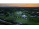 Sprawling property with a home, workshop, and dock along a tranquil river at sunset at 775 Bay Dr, New Smyrna Beach, FL 32168