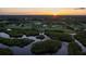 Picturesque waterfront home at sunset surrounded by mangrove islands and mature trees at 775 Bay Dr, New Smyrna Beach, FL 32168
