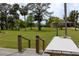View of sprawling backyard and home from the dock featuring palm trees, a lush lawn, and mature trees at 775 Bay Dr, New Smyrna Beach, FL 32168