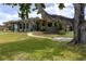 Beautiful backyard with a covered patio, lush lawn, and mature trees at 775 Bay Dr, New Smyrna Beach, FL 32168