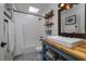Clean bathroom featuring a shower/bathtub combo, floating shelves, and wood countertop sink at 775 Bay Dr, New Smyrna Beach, FL 32168