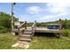 Outdoor dock featuring a sink, cooler and chairs with access to the river, surrounded by lush greenery and vegetation at 775 Bay Dr, New Smyrna Beach, FL 32168