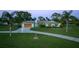 Single-story home with a well-manicured lawn, mature palms, and a spacious driveway at 775 Bay Dr, New Smyrna Beach, FL 32168