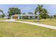 Charming single-story home featuring a manicured lawn and a long driveway at 775 Bay Dr, New Smyrna Beach, FL 32168