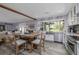 Charming kitchen featuring a dining table, stainless steel appliances, and a large window overlooking the backyard at 775 Bay Dr, New Smyrna Beach, FL 32168