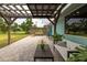 Serene patio area offering an ideal relaxation spot, accentuated by brick pavers, pergola, lush plants, and comfortable seating at 775 Bay Dr, New Smyrna Beach, FL 32168